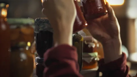 Man examines fermentation products in a rustic cellar environment 스톡 동영상 331354632