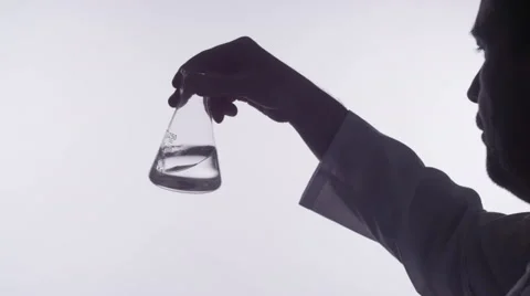 Man examines a flask with liquid Stock Footage 62743214