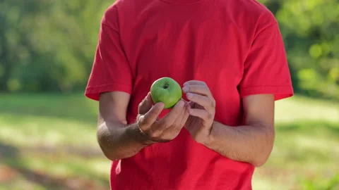 The man examines the green apple Stock-Footage 141818738