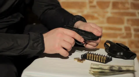 Man examines a gun Stock Footage 26631952