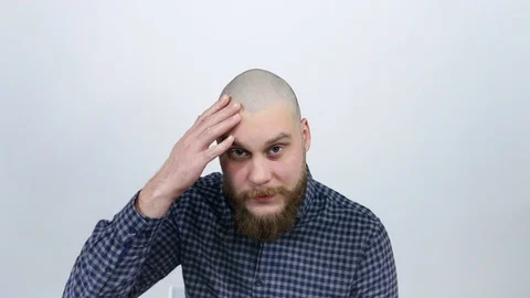 A man examines his bald head in the reflection and experiencing from hair loss Stock Footage 122012483