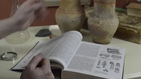 A man examines an old pitcher Stock Footage 74339830