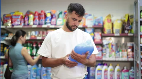 Man examines product liquid detergent in store Stock Footage 341430384