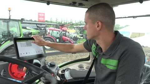 A man examines a tablet in a tractor. Medium Shot Stock Footage 303305084