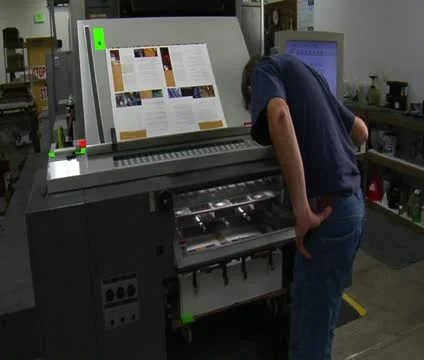 Man examines work from printing press Stock Footage 21596436