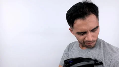 Man Examining a Black Object Against White Background. Stock Footage 315435044