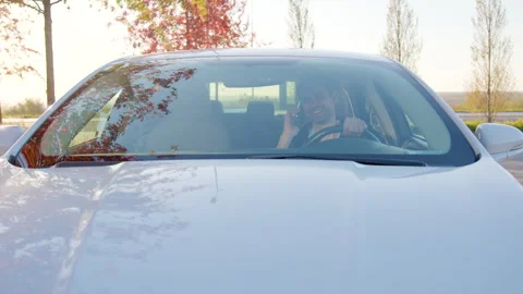 Man examining car interior before test drive, seated in vehicle with phone in Stock Footage 317701930