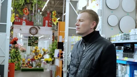 Man examining ceiling lights in a hardware store. Walking through the lighting Stock Footage 311462573