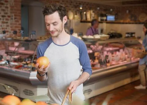 Man examining grapefruit in market Stock Photos