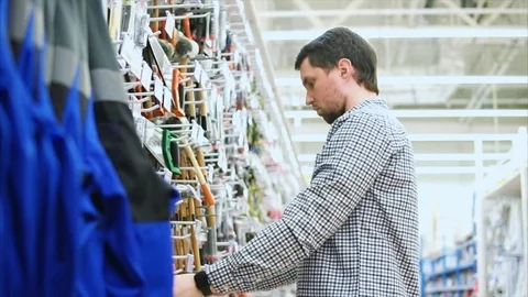 Man examining handsaw in tool store Stock Footage 75680215