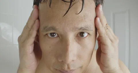 A man examining his face after clean the skin. Stock Footage 238689650