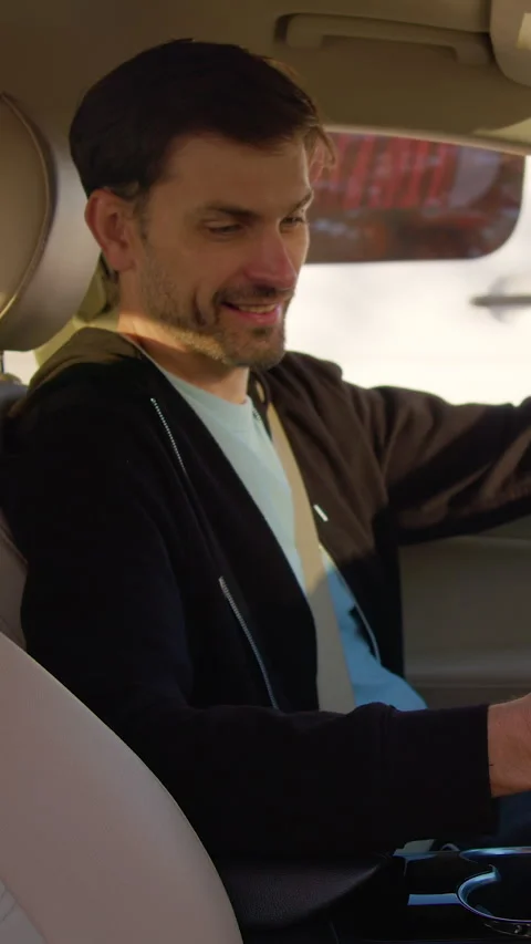 Man examining interior of car before test drive, holding smartphone, showcasing Stock Footage 318473156