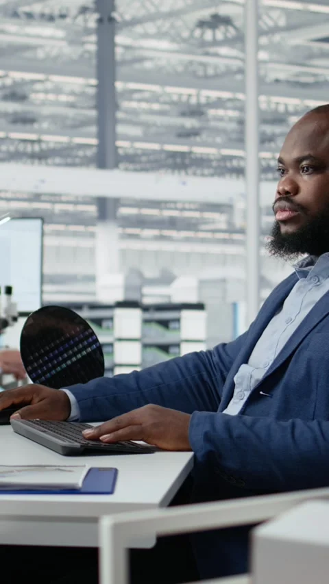 Man examining microchip circuit layouts on computer monitor in factory RD office Stock Footage 335882806