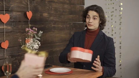 Man exchanging presents with girlfriend and typing on smartphone Stock Footage 124526010