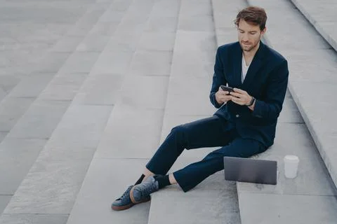 Man executive worker uses mobile phone for chatting works remotely makes project Stock Photos