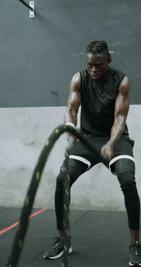 Man, exercise and battle rope in gym with coach, strength training and cardio Stock Footage 329741857