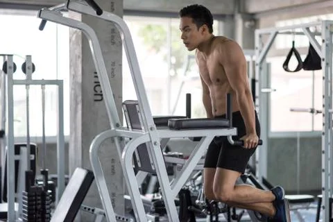 Man exercise on arm machine in gym Stock Photos