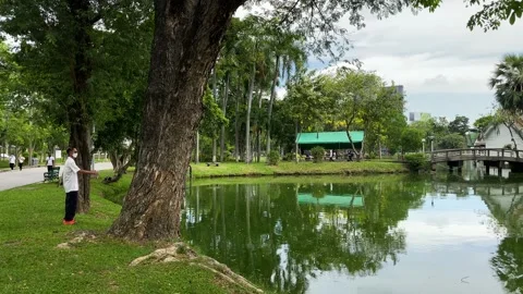 A man exercise in front of Lumpini Park pond, Bangkok, Thailand 4K Stock Footage 172401551