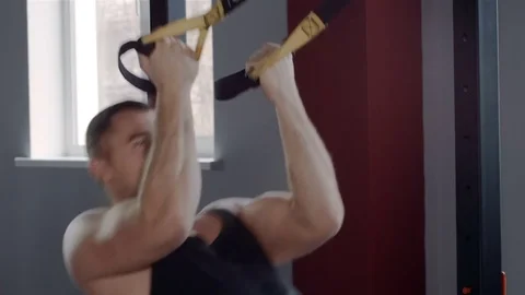 Man exercise at a gym by using bungee training Stockbeeldmateriaal 73933712