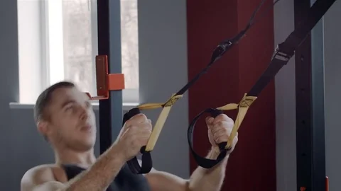 Man exercise at a gym by using bungee training Stockbeeldmateriaal 73934121