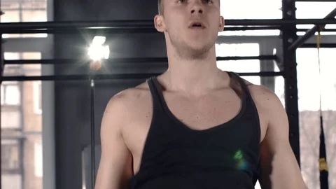 Man exercise at a gym by using bungee training Stock Footage 77325461