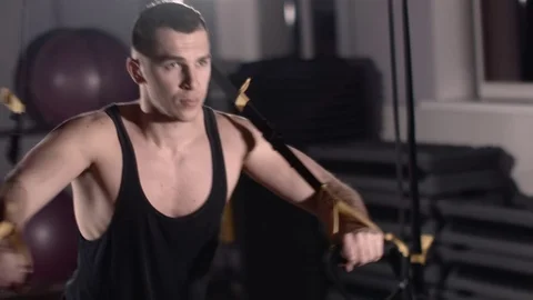 Man exercise at a gym by using bungee training Stockbeeldmateriaal 77326370