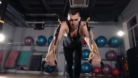 Man exercise at a gym by using bungee training Stockbeeldmateriaal 77326757