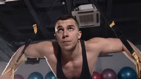Man exercise at a gym by using bungee training Stockbeeldmateriaal 77326944