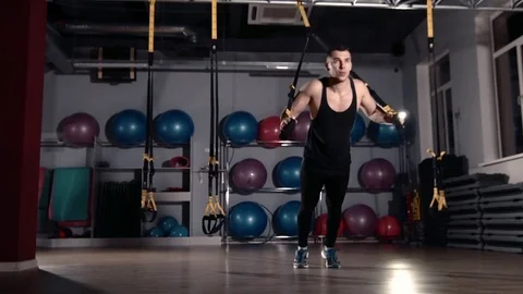 Man exercise at a gym by using bungee training Stockbeeldmateriaal 77327145