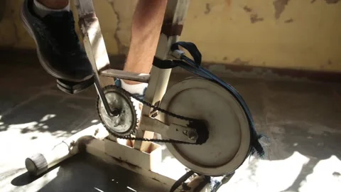 A man exercise on a old, vintage, precarious static bicycle on a low income hous Stock Footage 139425730