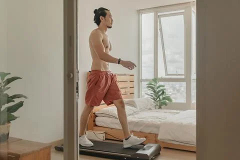 Man exercise by walking on the treadmill in his apartment. Fotos de archivo