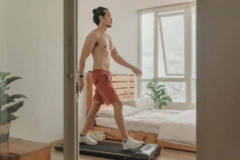 Man exercise by walking on the treadmill in his apartment. Fotos de archivo