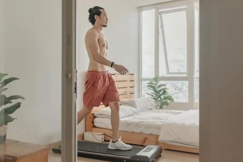 Man exercise by walking on the treadmill in his apartment. Fotos de archivo