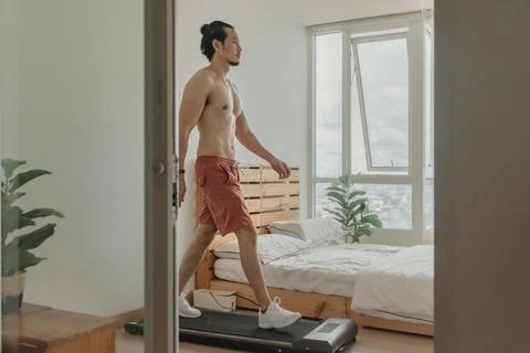 Man exercise by walking on the treadmill in his apartment. Fotos de archivo