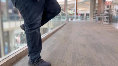 Man Exercises Knee Replacement in Mall Stock Footage 306552849