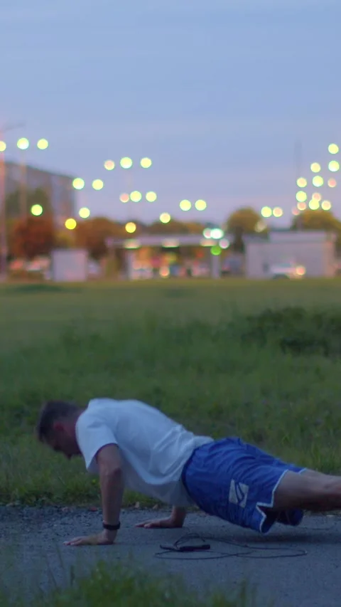 A man exercises in a park, showing determination and fitness commitment 動画素材 317340847