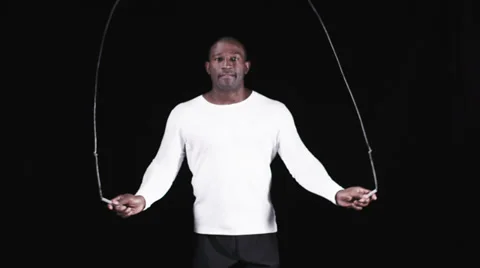 Man exercising on black background with skipping rope Vídeo Stock 32957450