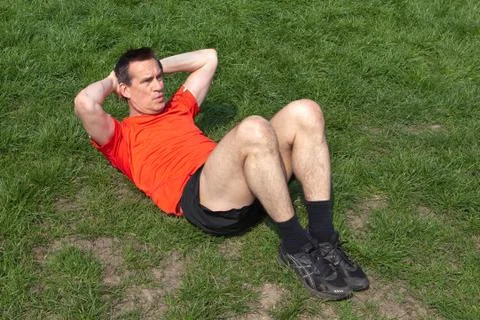 Man exercising doing situps on the grass Stock-Fotos