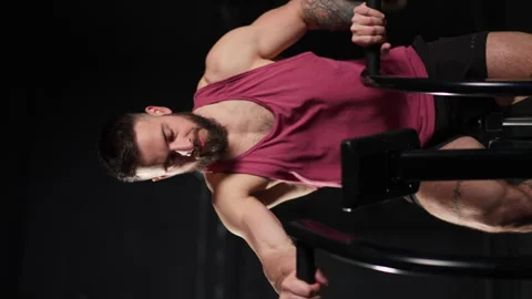 Man exercising on elliptical cross-trainer machine, wearing activewear. Routine Stock Footage 276273425