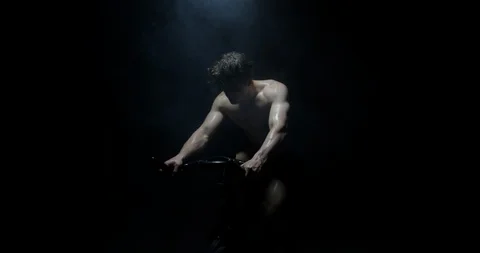 Man Exercising On Exercise Bike Shirtless Training As Smoke Falls On Him  Stock Footage 113889636