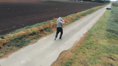 Man exercising outdoors between green meadows on an asphalt path. HD footage. Stock Footage 147742313