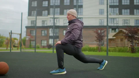 Man exercising outdoors, Caucasian elderly man practicing basketball warmup Stock Footage 327376949