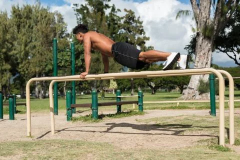 Man exercising on parallel bar in the park Stock Photos