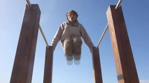 Man exercising on parallel bars outdoors Stock Footage 56279065