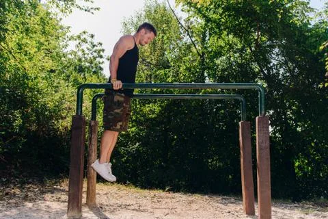 Man exercising on parallel bars outdoors Foto stock