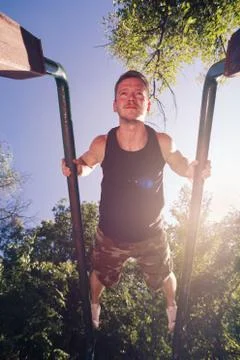 Man exercising on parallel bars outdoors Foto stock