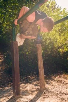 Man exercising on parallel bars outdoors Stock Photos
