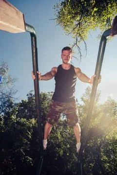 Man exercising on parallel bars outdoors 写真素材