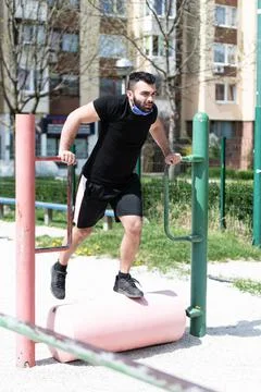 Man Exercising On Parallel Bars Outdoors Stock Photos
