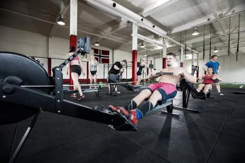 Man Exercising On Rowing Machine In Gym Stock Photos